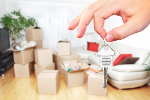 Movers carrying boxes and furniture through a Southfields flat