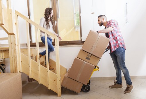 Packed moving boxes and furniture ready for transport in Southfields