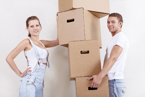 Removalists carrying furniture through a Southfields flat or house entrance